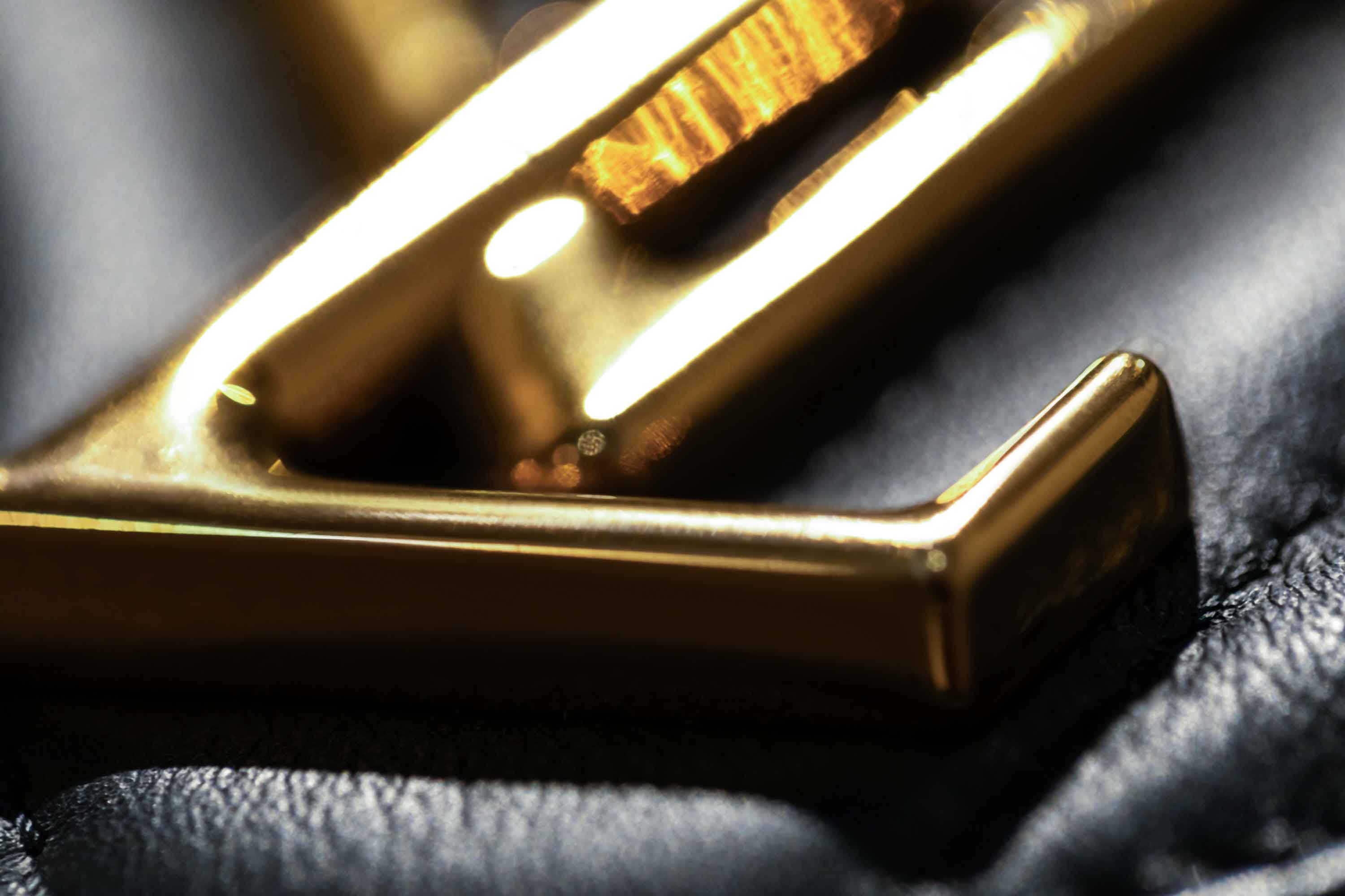 A luxury macro photography series showcasing close-up gold designer handbag hardware, polished metallic details and textured black leather. Captured with dramatic lighting, shallow depth of field and rich editorial styling, these images highlight premium fashion craftsmanship, elegant accessory design and high-end product detail.