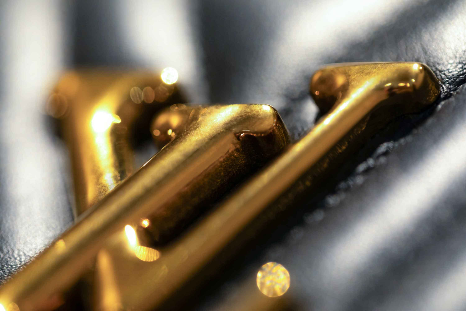 A luxury macro photography series showcasing close-up gold designer handbag hardware, polished metallic details and textured black leather. Captured with dramatic lighting, shallow depth of field and rich editorial styling, these images highlight premium fashion craftsmanship, elegant accessory design and high-end product detail.