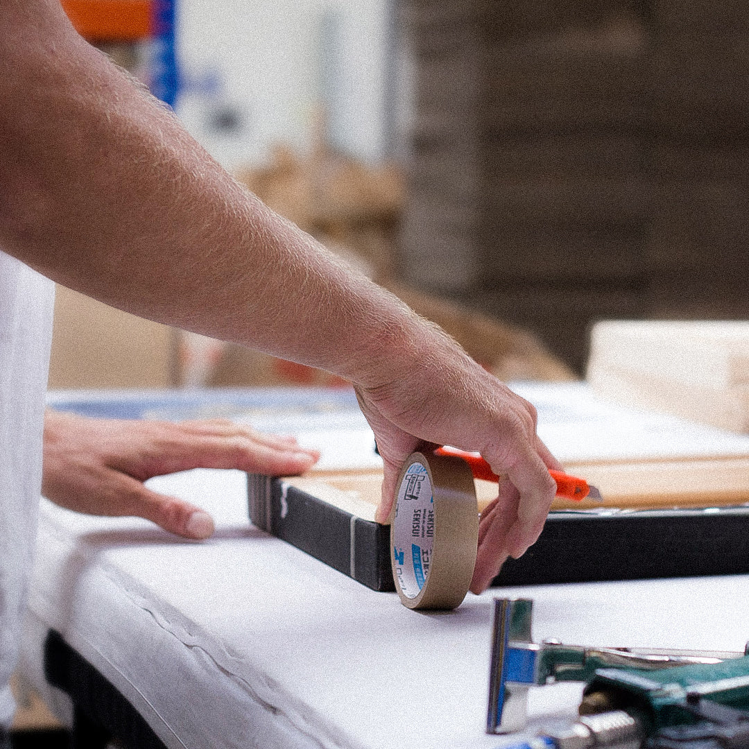Behind the scenes workshop photography showing handcrafted framing, print finishing and creative production processes. These documentary style images capture the care, detail and craftsmanship behind Quindie’s art prints, framed artwork and design led products.